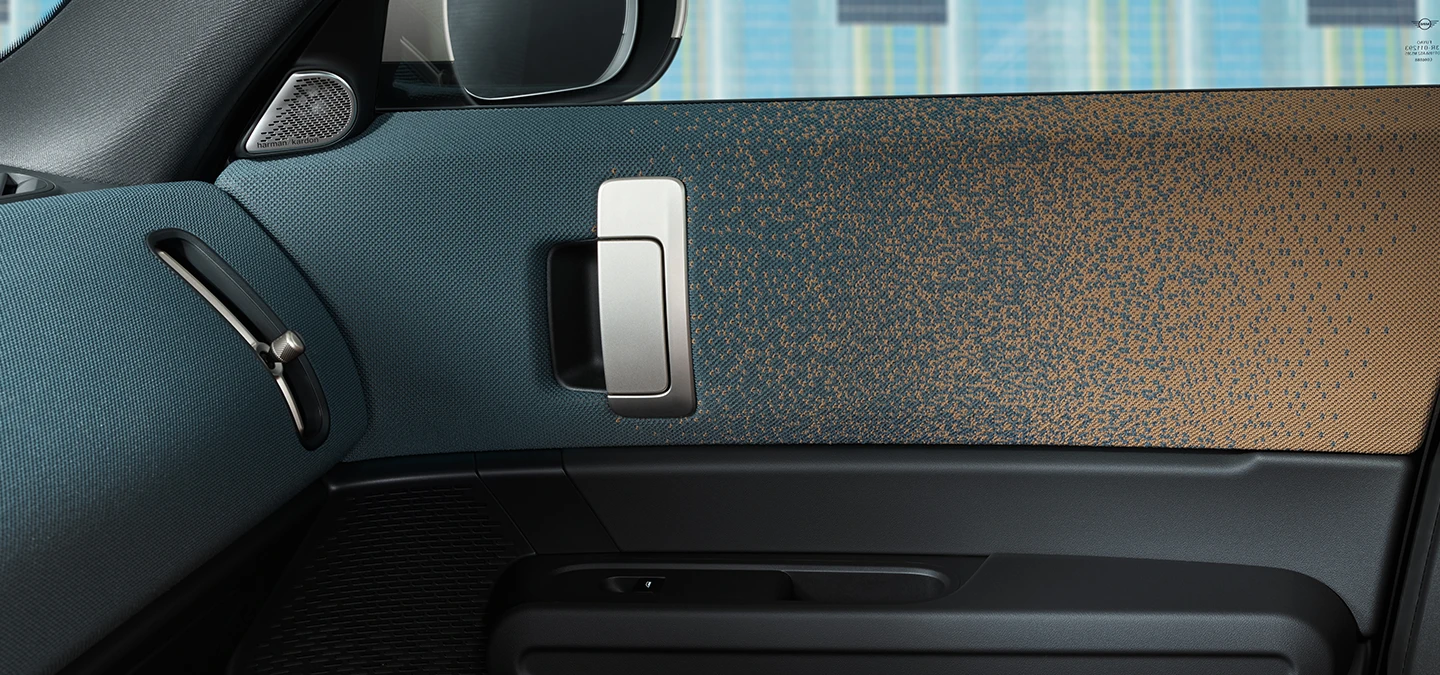 מבט מקרוב על העיצוב הפנימי של ה-MINI Countryman החשמלית עם דגש על הדלת ולוח המכשירים.